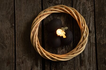 church candle and easter stand on an wooden table on quarantine easter dayの写真素材