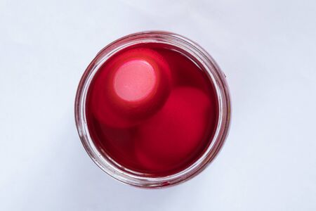 jar with red paint and eggs in it, preparation for Easter coloringの写真素材
