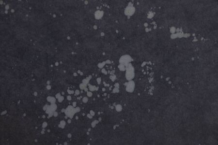 black paper background with small spots on itの写真素材
