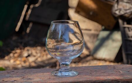 an empty transparent glass goblet stands on the groundの写真素材