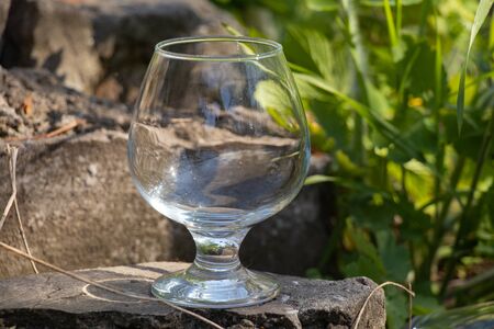an empty transparent glass goblet stands on the groundの写真素材