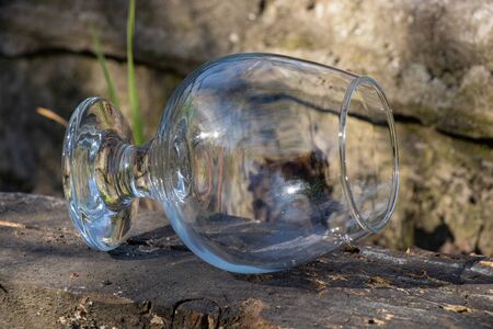 an empty transparent glass goblet stands on the groundの写真素材