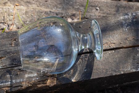 an empty transparent glass goblet stands on the groundの写真素材
