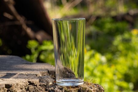 an empty transparent glass goblet stands on the groundの写真素材