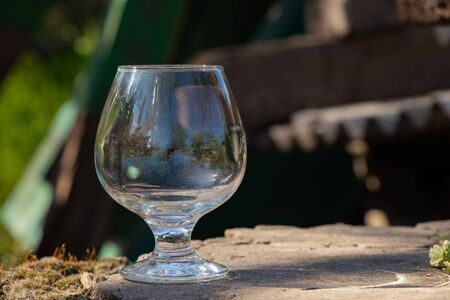 an empty transparent glass goblet stands on the groundの写真素材