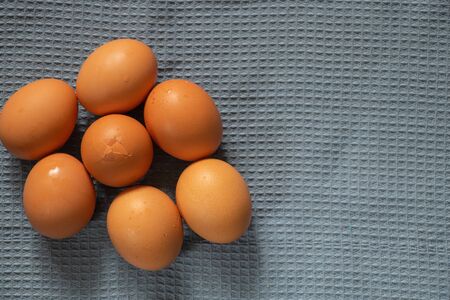 yellow chicken eggs in a plate lie on a tablecloth