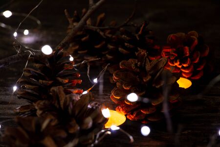 Christmas decor on a wooden board as a fonds with a garland and Christmas cones