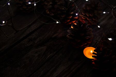Christmas decor on a wooden board as a fonds with a garland and Christmas conesの写真素材