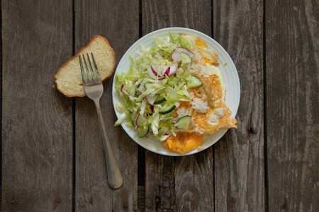 fried egg salad and bread on the table for breakfastの写真素材