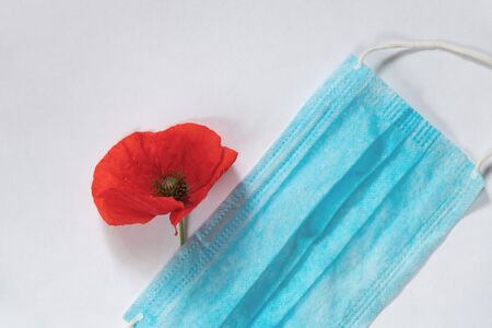 medical mask and poppy flower on the tableの写真素材