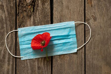 medical mask and poppy flower on the tableの写真素材