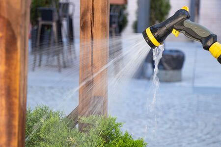 man watering club in parks through a sprinkler during the dayの写真素材