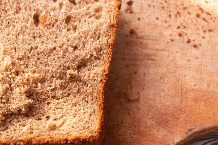 brown bread lies on a wooden board on a tableの写真素材