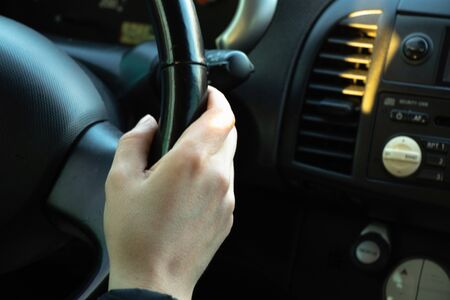 hands on the steering wheel inside the car in the afternoonの写真素材