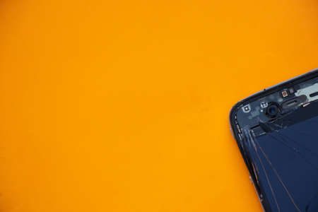 Ukraine, Dnipro - April 03, 2020. An old broken iPhone 4 lies on an orange backgroundのeditorial素材