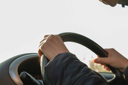 hands on the steering wheel inside the car in the afternoonの写真素材