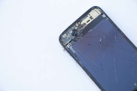 Ukraine, Dnipro - April 03, 2020. An old broken iPhone 4 lies on a white background