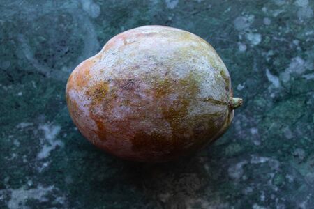 ripe mango close-up lies on the tableの写真素材