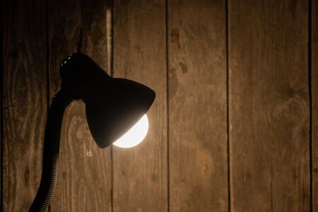 table lamp on in a dark room on the table illuminatesの写真素材