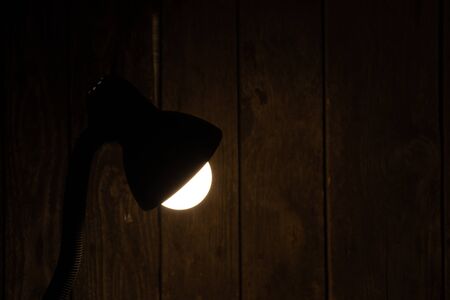 table lamp on in a dark room on the table illuminatesの写真素材
