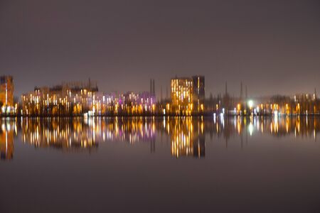 night skyscrapers in the reflection of the Dnieper river in the city of Dnipro in Ukraineの写真素材