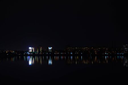 night skyscrapers in the reflection of the Dnieper river in the city of Dnipro in Ukraineの写真素材