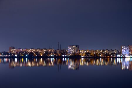 night skyscrapers in the reflection of the Dnieper river in the city of Dnipro in Ukraineの写真素材