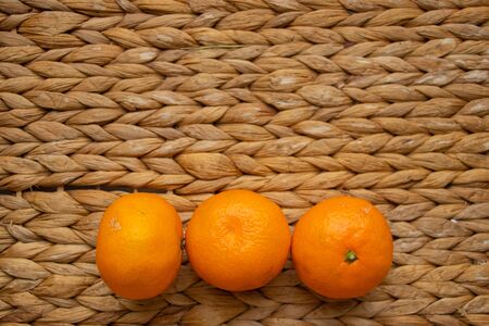 tangerines lie on a straw trayの写真素材