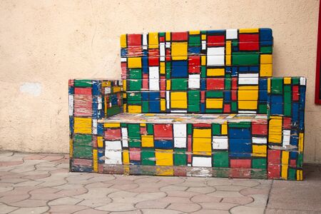 old wooden multi-colored sofa stands on the street in the city of Dnieper in Ukraineの写真素材