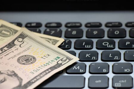 dollars on laptop keyboard close-up on the tableの写真素材