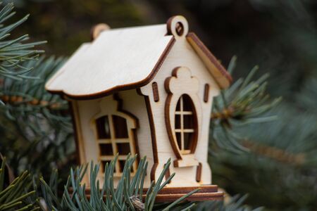 small wooden house on the branches of a Christmas tree closeupの写真素材
