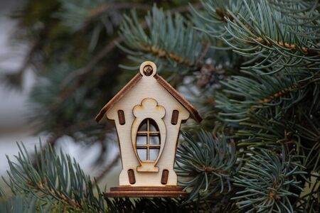 small wooden house on the branches of a Christmas treeの写真素材