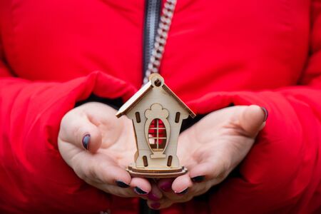 Girl holds a small wooden house outdoors in the afternoonの写真素材