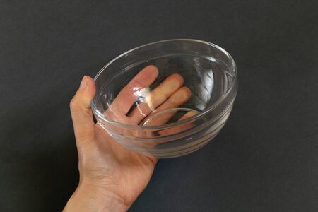 empty empty plate in the hands of a girl on an isolated backgroundの写真素材