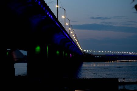 Old bridge in the evening with backlight in the city of Dnieperの写真素材