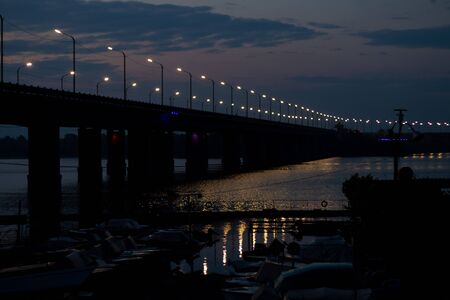 Old bridge in the evening with backlight in the city of Dnieperの写真素材