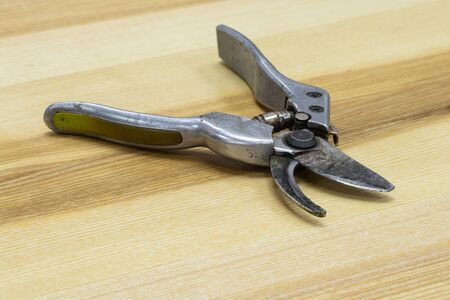 scissors for cutting branches lie on a wooden tableの写真素材