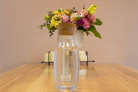 water jar on the table and a vase of flowersの写真素材