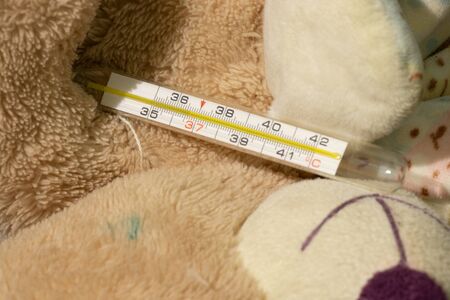 baby teddy bear with thermometer close-upの写真素材