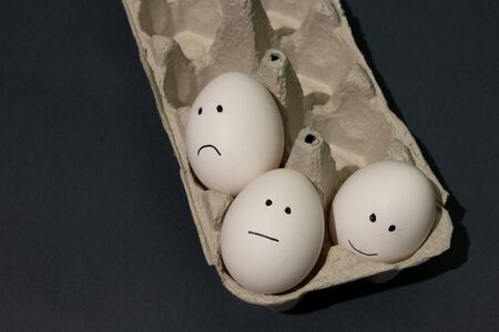 on a white egg, eyes and mouth are drawn with a black felt-tip pen on an isolated background