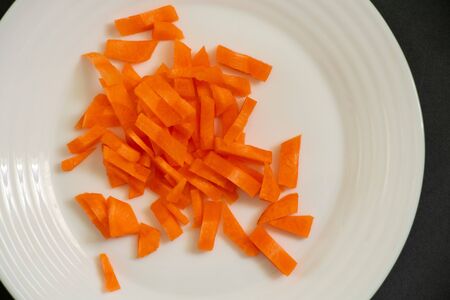 chopped carrots julienne on a plate on a dark backgroundの写真素材