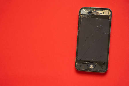 Ukraine, Dnipro - April 04, 2020. An old broken iPhone 4 lies on an orange background close-up.のeditorial素材