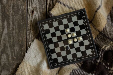 chess and plaid lie on a wooden floorの写真素材