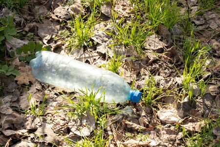 a plastic bottle lies on grass in nature thrown away like garbageの写真素材