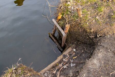 a wooden staircase descended into the river by the riverの写真素材