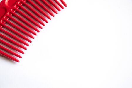 red plastic comb on a white background close-upの写真素材