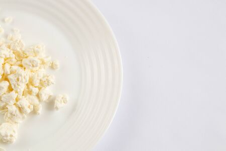 sour milk cottage cheese in a white bowl on a white background close-upの写真素材