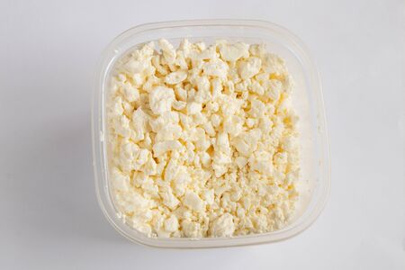 sour milk cottage cheese in a white bowl on a white background close-upの写真素材