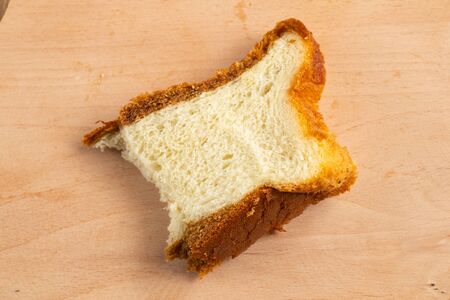 piece of homemade bread on a wooden board blackboard close-up in daylightの写真素材