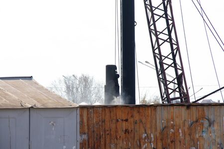 crane clogs piles on building a house in the afternoon on the streetの写真素材